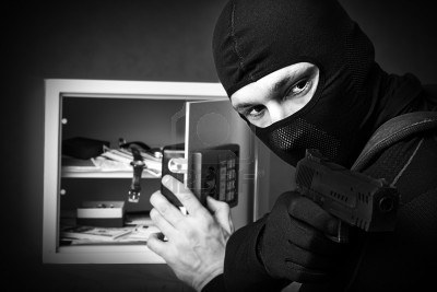 16992969-professional-burglar-in-black-mask-opened-a-small-safe-holding-hand-gun-and-aiming